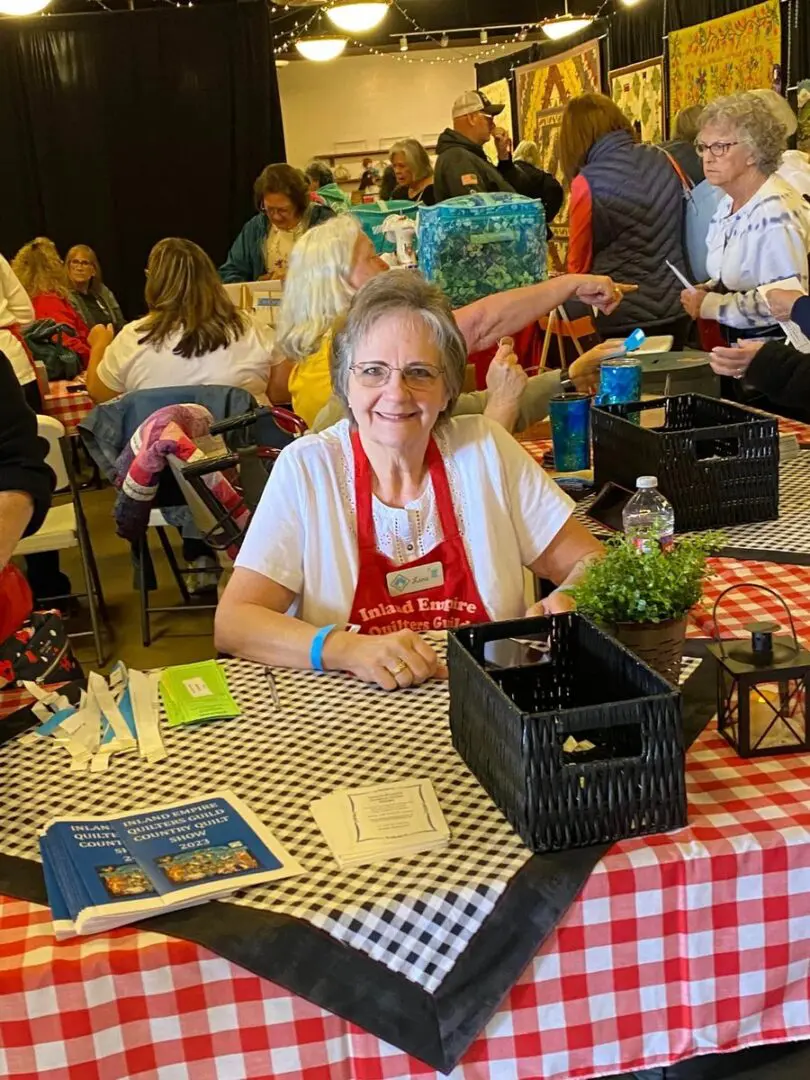 Woman sitting at a table with a red and white checkered table cloth
