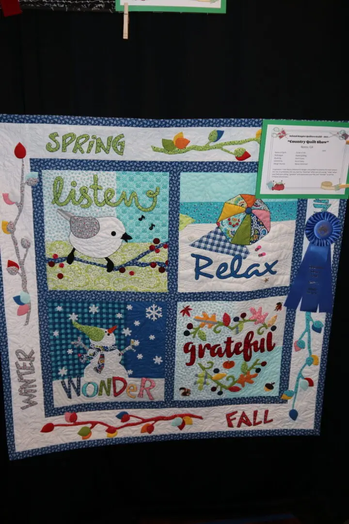 Quilted wall hanging on a wall next to a table