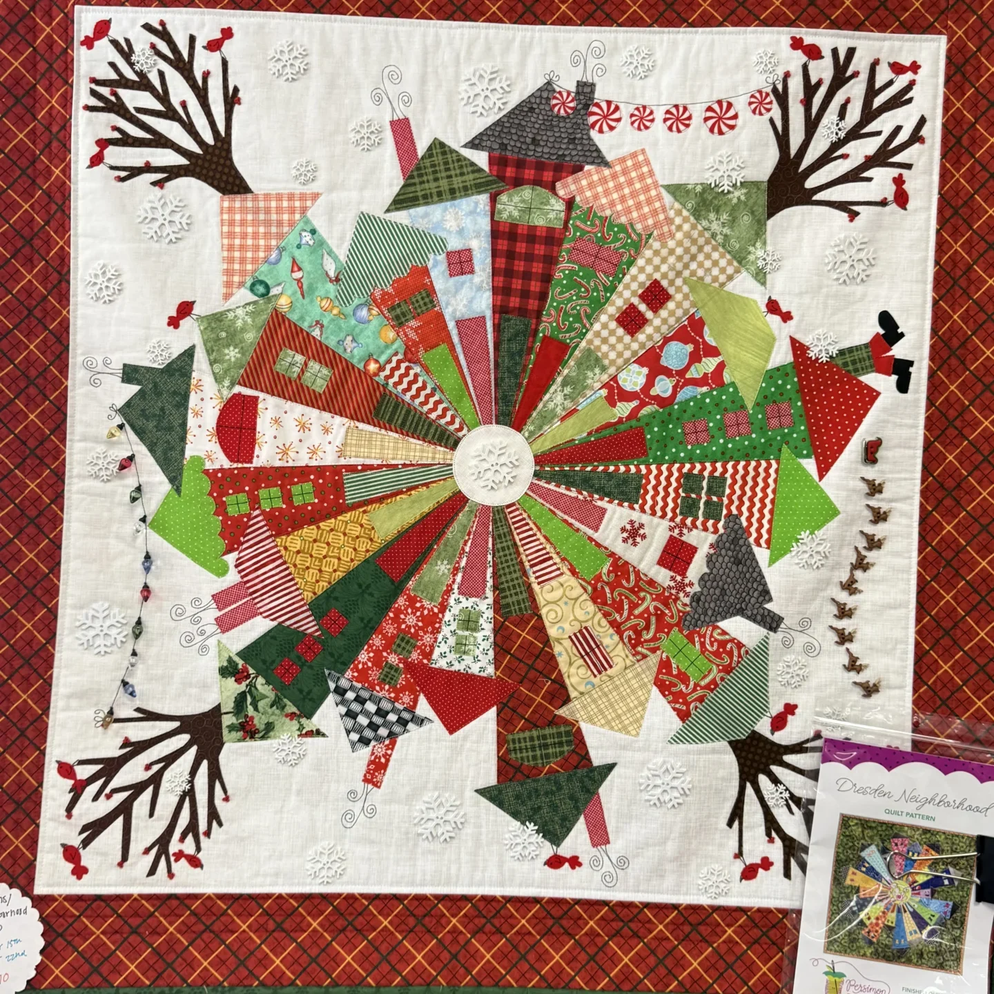 Quilted wall hanging on a wall next to a blackboard